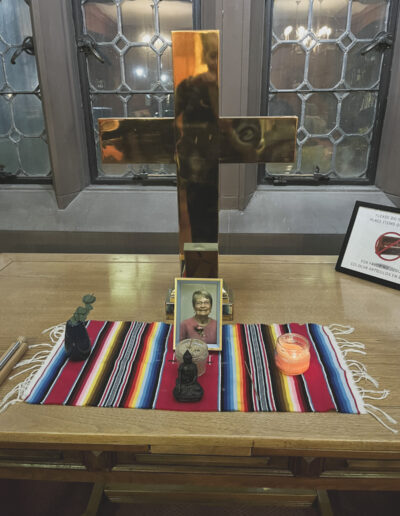 A table with a large gold cross and a photograph of Barbara Sensei Barbara Shoshin Craig