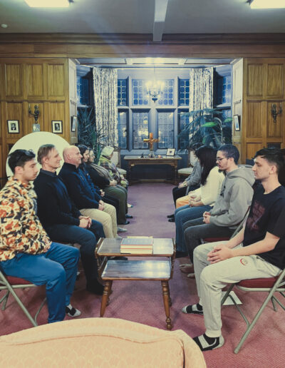 Group of adults lined up in chairs in a meditation session.